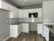 Modern kitchen featuring white cabinets, stainless steel microwave, and tile backsplash at 279 Constellation Ct, Benson, NC 27504