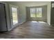 Bright living space with rear yard views, light, wood-look flooring and a rear door to a concrete patio at 279 Constellation Ct, Benson, NC 27504