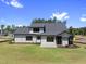 Rear view of a two-story home with dark framed windows, manicured lawn and a sunroom at 2809 Theresa Eileen Way, Raleigh, NC 27603