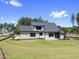 Rear view of a two-story home with dark framed windows, manicured lawn and a sunroom at 2809 Theresa Eileen Way, Raleigh, NC 27603
