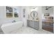 Bathroom featuring a standalone tub, gray vanity, and stylish fixtures, creating a spa-like atmosphere with natural light at 2809 Theresa Eileen Way, Raleigh, NC 27603