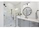 Modern bathroom with a glass enclosed shower with marble details, gray vanity, and black accents for a sleek design at 2809 Theresa Eileen Way, Raleigh, NC 27603
