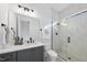 Modern bathroom with a glass enclosed shower with white brick style details, gray vanity, and black accents for a sleek design at 2809 Theresa Eileen Way, Raleigh, NC 27603