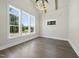 Bright bedroom with hardwood floors, modern light fixture and three large windows at 2809 Theresa Eileen Way, Raleigh, NC 27603