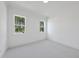 Bright bedroom featuring neutral carpet, white trim, and large windows with outside views at 2809 Theresa Eileen Way, Raleigh, NC 27603