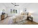Bright primary bedroom featuring tray ceilings, wood floors, large windows and stylish decor, creating a cozy and elegant space at 2809 Theresa Eileen Way, Raleigh, NC 27603