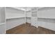 Walk-in closet featuring custom shelving, a dresser, and hardwood floors at 2809 Theresa Eileen Way, Raleigh, NC 27603
