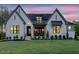 Charming exterior of a white painted brick home with gray accents and a well-manicured lawn at twilight at 2809 Theresa Eileen Way, Raleigh, NC 27603