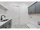 Well-lit laundry room with gray cabinets, modern fixtures and decorative tile flooring at 2809 Theresa Eileen Way, Raleigh, NC 27603
