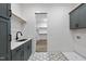 Laundry room featuring gray cabinets, a utility sink and patterned flooring at 2809 Theresa Eileen Way, Raleigh, NC 27603
