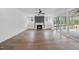 A spacious living room featuring hardwood floors, a fireplace, custom cabinetry, and a large sliding glass door at 2809 Theresa Eileen Way, Raleigh, NC 27603