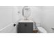 Powder room featuring a gray vanity, gold hardware, decorative mirror and a modern toilet at 2809 Theresa Eileen Way, Raleigh, NC 27603