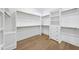 Spacious walk-in closet with ample shelving and drawer space, providing an organized storage solution with wood flooring at 2809 Theresa Eileen Way, Raleigh, NC 27603