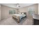 Spacious carpeted bedroom with natural light, ceiling fan and a queen bed with stylish bedding at 30 Holly Berry Ln, Durham, NC 27703