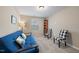 Neutral bedroom featuring a blue futon sofa with throw pillows, carpeted floor and natural light at 30 Holly Berry Ln, Durham, NC 27703