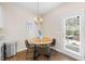 A sunlit breakfast nook with wood table and seating sits adjacent to an exit door to the backyard at 30 Holly Berry Ln, Durham, NC 27703
