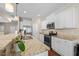 Bright eat-in kitchen featuring white cabinets, granite countertops, stainless appliances, and hardwood floors at 30 Holly Berry Ln, Durham, NC 27703