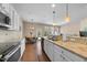 A modern kitchen with white cabinets, granite countertops, and stainless steel appliances flows into the breakfast nook at 30 Holly Berry Ln, Durham, NC 27703