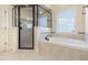 Bright bathroom featuring a shower and tub, and neutral tile throughout at 3034 E Bay Court, Creedmoor, NC 27522