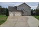 Home featuring a two-car garage and a basketball court; gray siding, well-maintained landscaping, and a spacious driveway at 3034 E Bay Court, Creedmoor, NC 27522