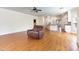 Open concept living room showcases hardwood floors, a ceiling fan, and transitions to a modern kitchen at 3034 E Bay Court, Creedmoor, NC 27522
