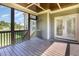 View of a screened in porch with exposed ceiling beams and outdoor furniture at 3034 E Bay Court, Creedmoor, NC 27522