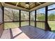 Screened in porch showing wood flooring and scenic views of the property's landscape at 3034 E Bay Court, Creedmoor, NC 27522