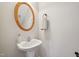 Cozy half bathroom offers a classic pedestal sink with oval mirror above at 304 Frontgate Dr, Cary, NC 27519