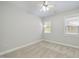Cozy bedroom with neutral carpet, ceiling fan, and sunlit windows, perfect for relaxation and rest at 304 Frontgate Dr, Cary, NC 27519