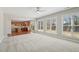 Bright, open-concept living room with carpet, large windows, and an adjacent kitchen at 304 Frontgate Dr, Cary, NC 27519