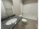Modern bathroom featuring granite counters, white cabinets and a shower-tub combo at 308 Busterfield Ct, Benson, NC 27504