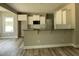Modern kitchen featuring white cabinets, granite countertops, and stainless steel appliances, seamlessly connecting to an open living space at 308 Busterfield Ct, Benson, NC 27504