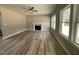 Bright living room featuring a fireplace, ceiling fan, and large windows for ample light at 308 Busterfield Ct, Benson, NC 27504