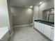 Elegant main bathroom featuring double vanity, granite countertops, tile flooring, soaking tub, and glass enclosed shower at 308 Busterfield Ct, Benson, NC 27504