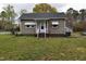 Charming single-story home featuring a covered front porch and a well-maintained lawn at 312 W Steele St, Gibsonville, NC 27249
