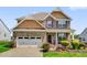 Charming two-story home with brick accents, a two-car garage, and a professionally landscaped front yard at 343 Brinkley Cir, Mebane, NC 27302