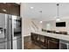 Open kitchen view showcases stainless steel fridge, granite countertops, and leads into living room at 343 Brinkley Cir, Mebane, NC 27302