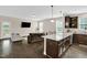 Open-concept kitchen featuring stainless appliances, a granite island, and comfortable living area at 343 Brinkley Cir, Mebane, NC 27302