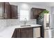 Well-lit kitchen with dark wood cabinets, stainless steel appliances, and sleek white countertops at 3905 Joe And Ruth Lee Dr, Raleigh, NC 27610