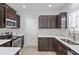 Modern kitchen with stainless steel appliances, stylish dark cabinets, and granite countertops at 3905 Joe And Ruth Lee Dr, Raleigh, NC 27610