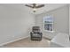 Carpeted bedroom featuring a plush gray recliner by a window and a ceiling fan at 404 Cotton Brook Dr, Fuquay Varina, NC 27526