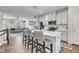 Bright kitchen features white cabinetry, stainless steel appliances and island with barstool seating, open to the living area at 404 Cotton Brook Dr, Fuquay Varina, NC 27526