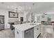 Open floor plan kitchen boasts quartz countertops, an island sink, and overlooks the dining and living areas at 404 Cotton Brook Dr, Fuquay Varina, NC 27526