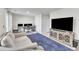 Cozy living room with a large TV, comfortable sofa, and stylish blue rug for a relaxing ambiance at 404 Cotton Brook Dr, Fuquay Varina, NC 27526