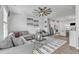 Stylish living room features an open layout with the kitchen, gray sofa, ceiling fan and ample natural light at 404 Cotton Brook Dr, Fuquay Varina, NC 27526