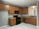 Well-lit kitchen features stainless steel appliances, wood cabinets, and tile floors at 4423 Sugarbend Way, Raleigh, NC 27606
