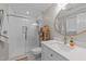 Bright bathroom with a glass shower, a large round mirror and a white vanity at 5120 Knaresborough Rd, Raleigh, NC 27612