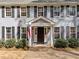 Inviting front porch with a gray-painted entrance and black door, flanked by meticulously maintained shrubs at 5120 Knaresborough Rd, Raleigh, NC 27612
