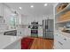 Modern kitchen boasts white cabinetry, subway tile backsplash, stainless steel appliances, and hardwood floors at 5120 Knaresborough Rd, Raleigh, NC 27612