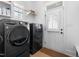This laundry room has black washer and dryer units with a view to the backyard at 524 Beckwith Ave, Clayton, NC 27527